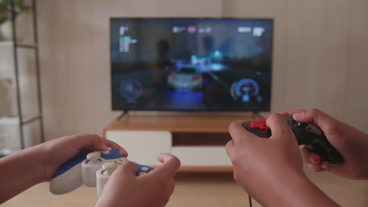 Close Up Children'S Hands Holding Joystick Game Play Racing Video Games On Tv