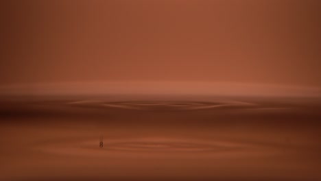 gota de agua en la superficie del agua sobre fondo naranja de cerca