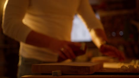 Close-up-of-person-filing-a-wooden-board-cut-in-a-workshop