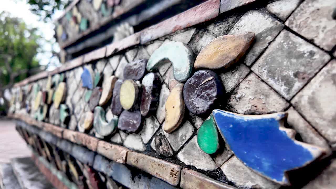 Wat Pho temple wall displaying ceramic mosaic made of broken pottery and vivid tiles