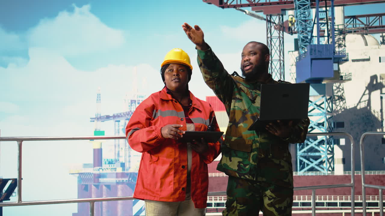 Vertical video Military personnel stationed on offshore rig evaluating surveillance footage