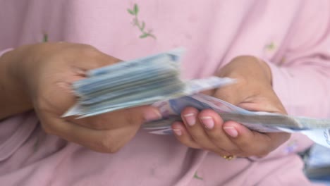 woman holding and counting money