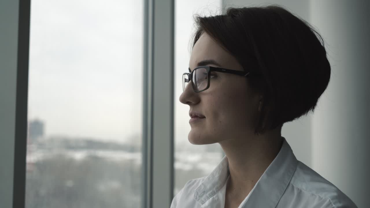 Una mujer mirando por la ventana.