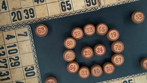 a creative close-up smooth zoom out rotating shot from above of a bingo wooden barrels in a circle, woody figures, old numbers background, vintage board game, professional lighting, slowmotion 120 fps