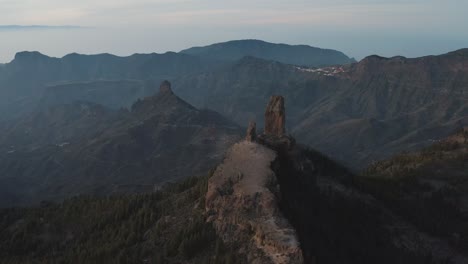 vuelo de drones de una gran roca en la cima de una montaña a la hora azul con, panorama de montaña, roque nublo, pico de las nieves, gran canaria