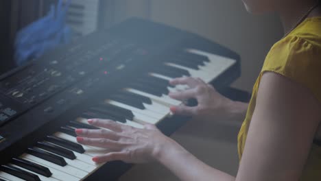 Ultra-High-Definition,-slow-motion,-medium-close-up-of-an-Asian-woman-practicing-on-a-keyboard