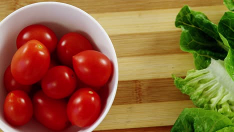 Lettuce-and-tomatoes-in-bowl-on-chopping-board