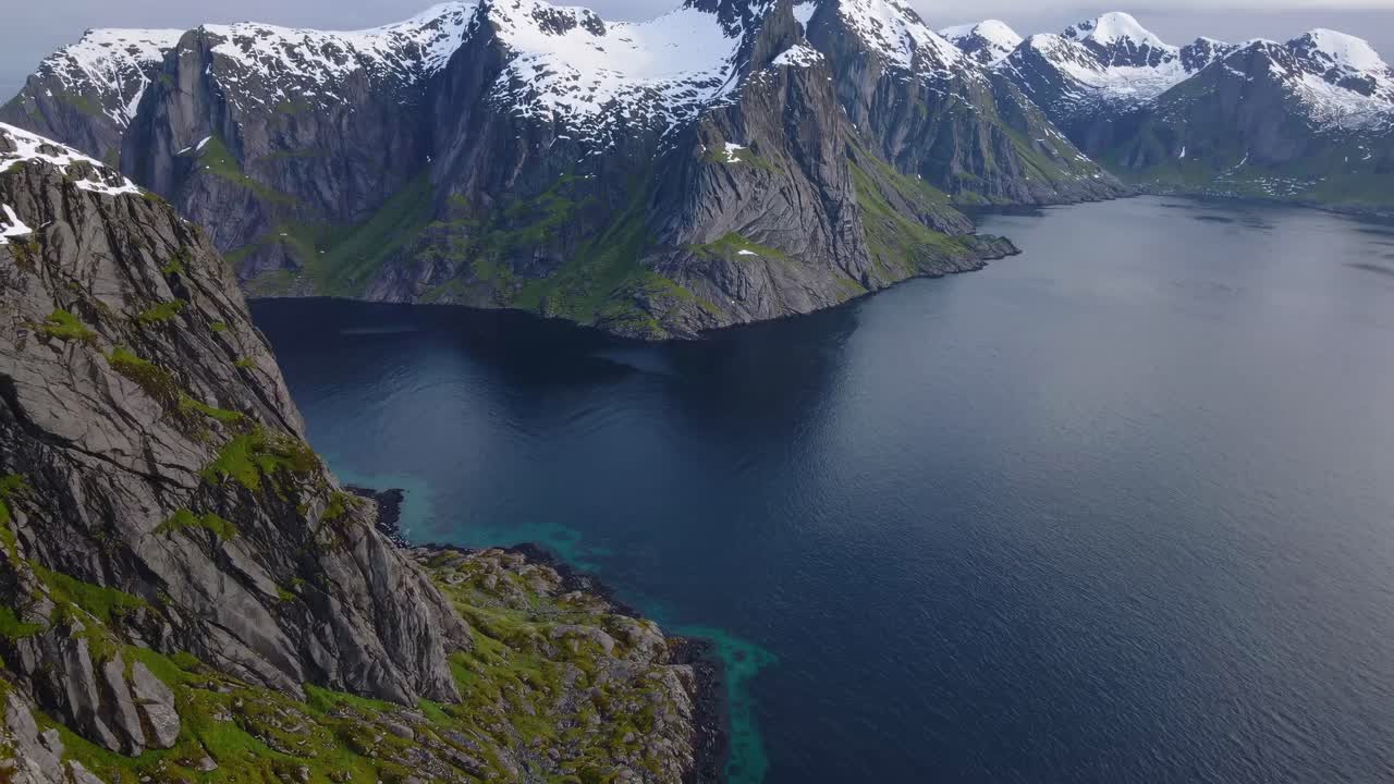 Luftaufnahme von majestätischen, schneebedeckten Bergen und einem friedlichen Fjord