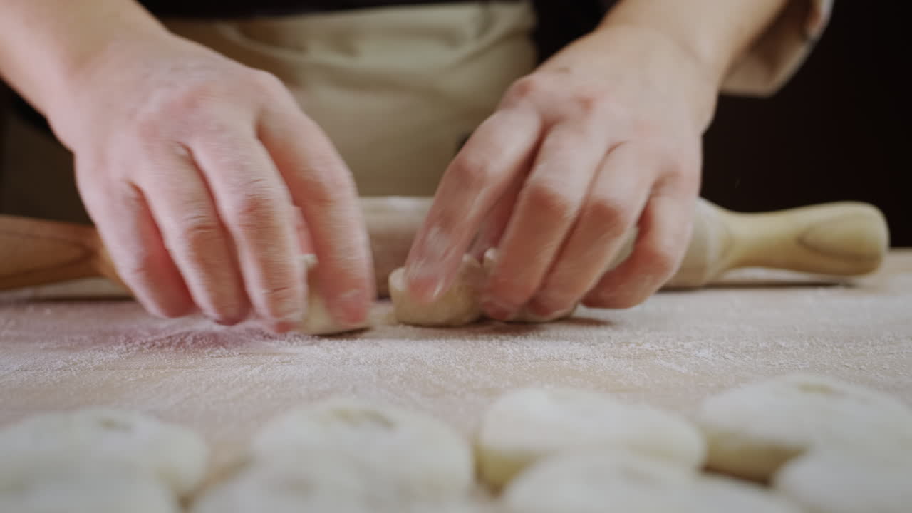 숙련 된  ⁇ 기 는  ⁇ 기 위한 반죽 을 굴린다. 그 의 움직임 은 빠르고 전문적 이다