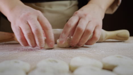 a skillful baker rolls out dough for baking. his movements are fast and professional