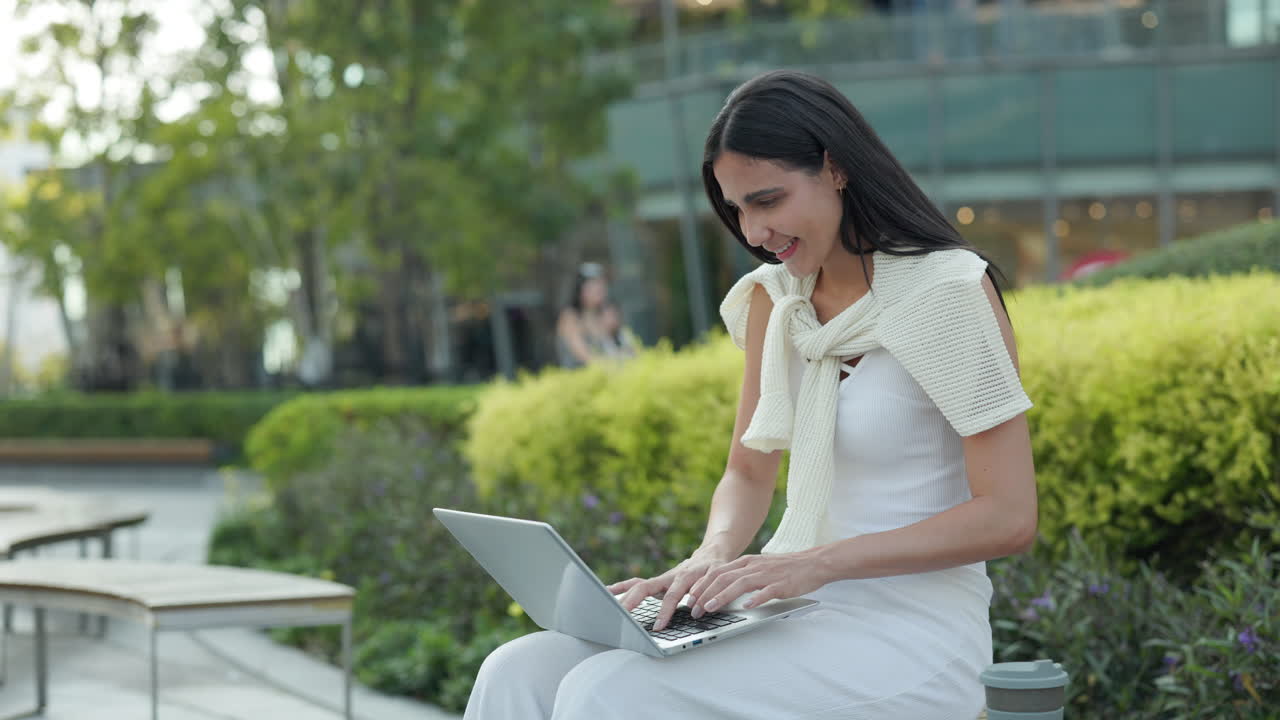 Woman working on laptop in the park