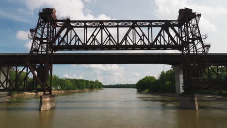 volando a través del puente de truss oxidado sobre el río blanco en twin city riverfront park, arkansas, ee.uu.