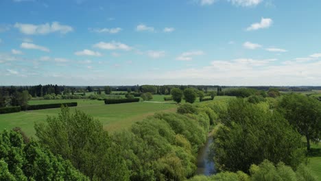 Aerial-ascent-revealing-beautiful-green-shades-of-trees-and-farmland-in-summertime---Selwyn-River-at-Coes-Ford-Recreation-Area