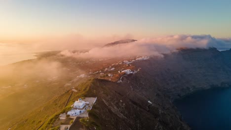 Aerial-sunrise-hyperlapse-over-clouds-and-caldera-cliff-in-Santorini-island,-Greece