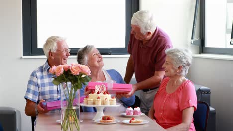 Senior-woman-receiving-gift-from-her-friend