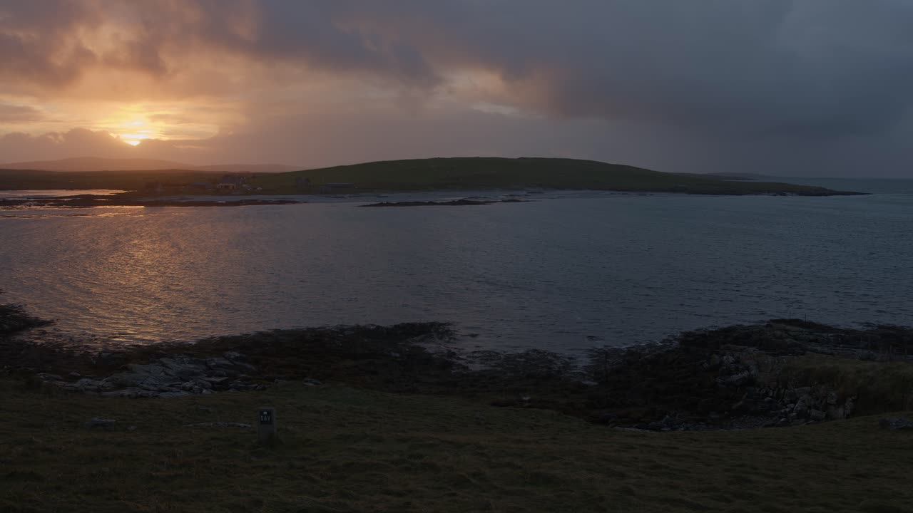 Golden hour shot of a sunset over the ocean during a storm over the island of North Uist