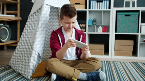 boy playing on smartphone in kids room