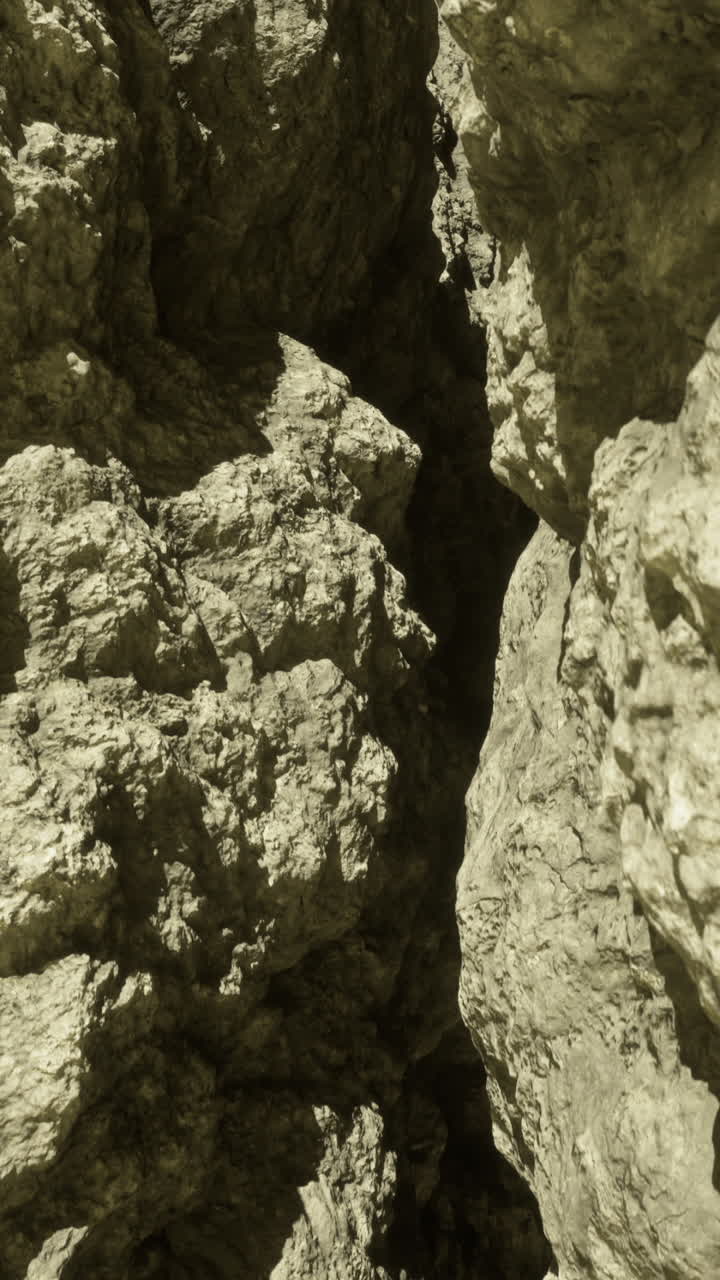 Exploring a narrow canyon with rugged rock formations at midday