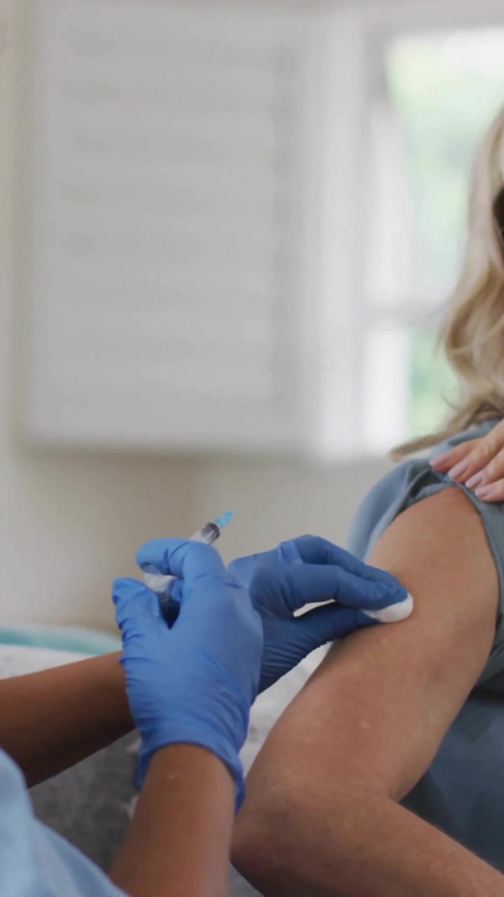 Animation of virus cells over female doctor with patient taking vaccine