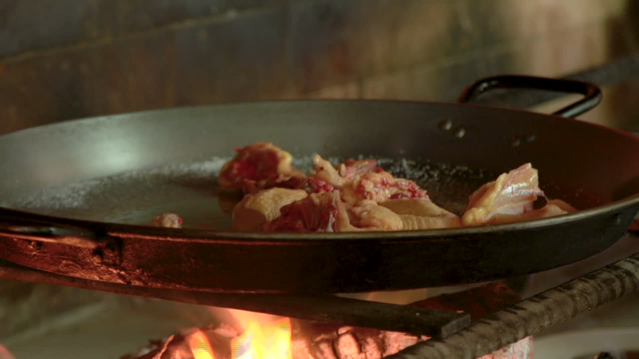 Preparazione di paella spagnola autentica e tradizionale con legna da ardere ardente a Barraca, Valencia
