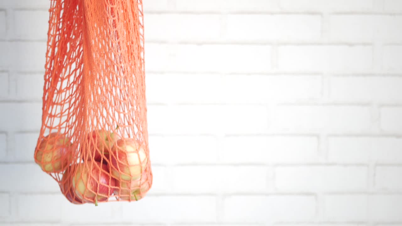 오렌지색 mesh 가방에 사과