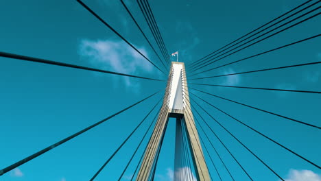 driving through anzac bridge in sydney, new south wales with view of cables and pylons against bright blue sky