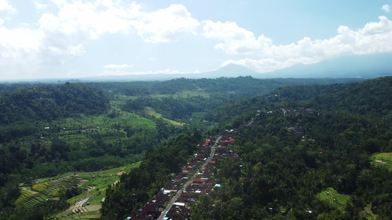 órbita aérea explorando las impresionantes vistas de la vasta belleza en sideman con una aldea debajo, bali, indonesia