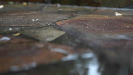 rain falls on a stone sidewalk