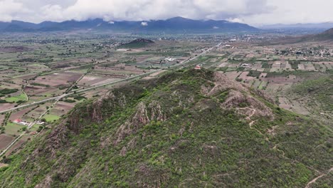 aerial view of a rural mountainous landscape with fields and a road