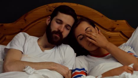 couple relaxing on bed in bedroom