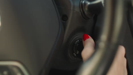 la mano de una mujer joven gira la llave de encendido en el coche que comienza el viaje