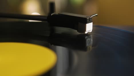 cerca de la cáscara de la cabeza de un reproductor de discos mientras un vinilo está girando