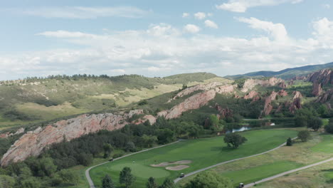 arrowhead golfbaanresort in littleton colorado met groen gras, rode rotsen en blauwe luchten