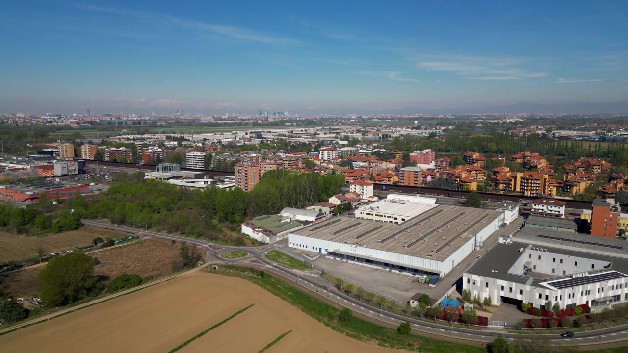 Vista drone di un'area mista industriale e residenziale a Zeloforamagno vicino a Milano, Italia. Edifici logistici e condomini che mostrano lo sviluppo urbano e le infrastrutture.