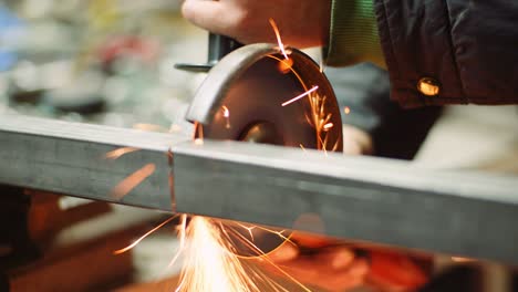 steel industry - man using angle grinder grinding metal object.