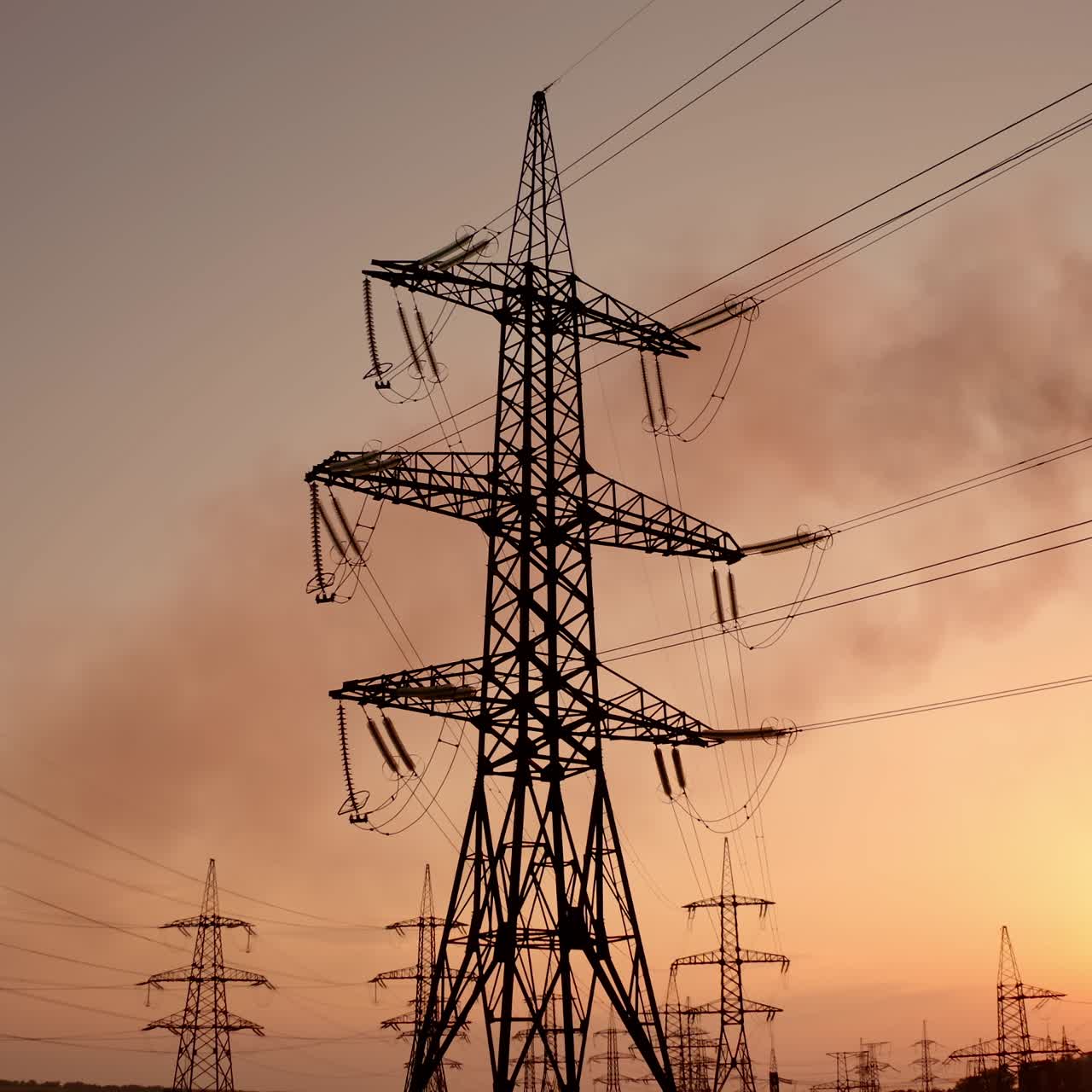 Electricity pylons at sunset. High-voltage electric tower on dirty sky background. Harmful smoke from industry filling the atmosphere. Air pollution