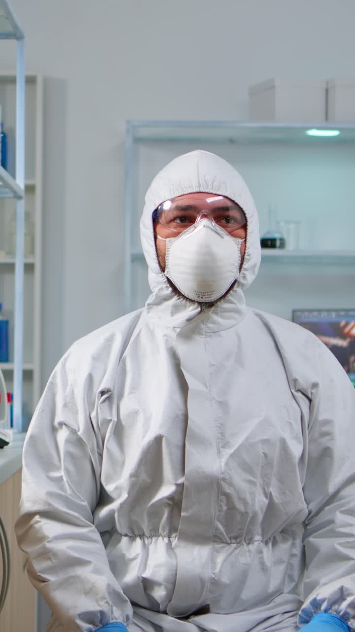 Vertical video: Lab technician in ppe suit working with virtual reality