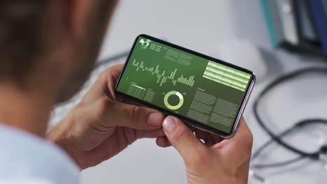 Hands-of-caucasian-man-using-smartphone-with-statistics-on-screen