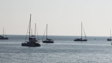 multiple sailboats floating on calm sea waters