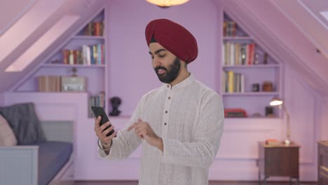 hombre indio sikh feliz usando el teléfono