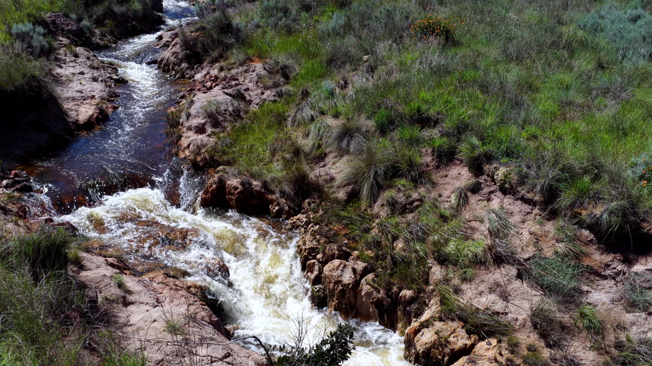 Calm water moving through natural channel in quiet rugged terrain