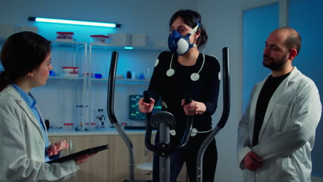 woman athlete with mask doing fitness exercises in science sport lab