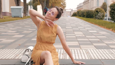 smiling woman in yellow polka dot dress on city street