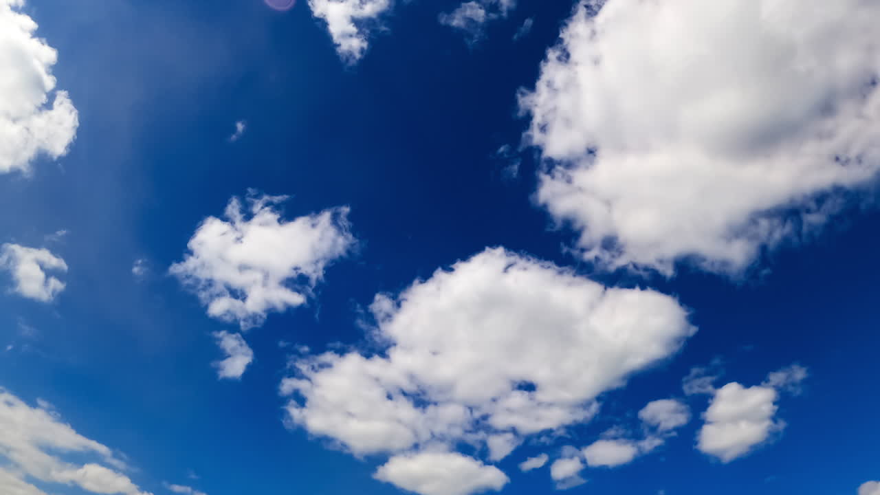 Stunning azure sky with fluffy clouds. Low angle view at the white clouds changing shapes in the atmosphere. Timelapse