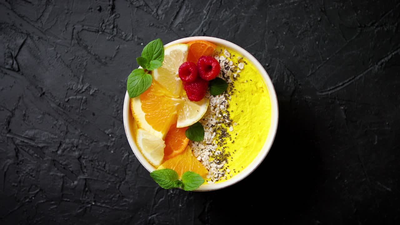 sabroso batido de naranja fresco o yogur servido en un tazón con frambuesas, rodajas de naranja, semillas de chía