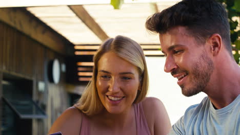 excited couple with credit card using laptop at home to book holiday or shop online