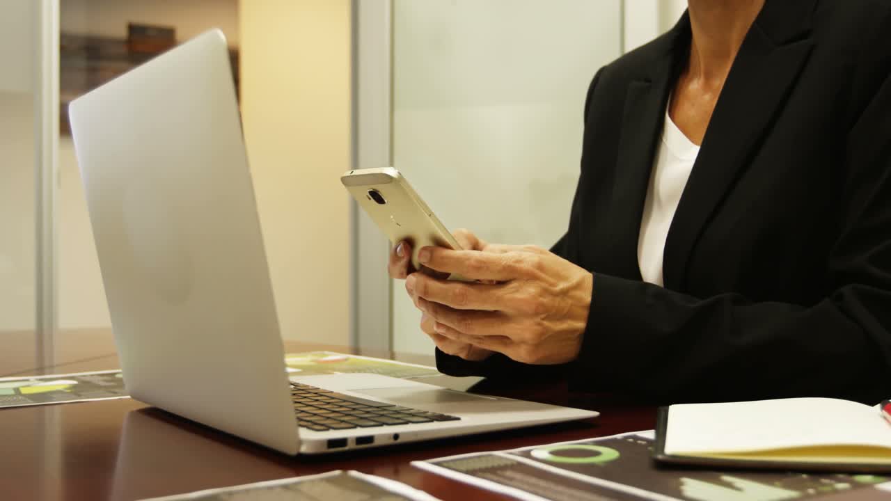 Donna d'affari che usa il cellulare alla scrivania 4k