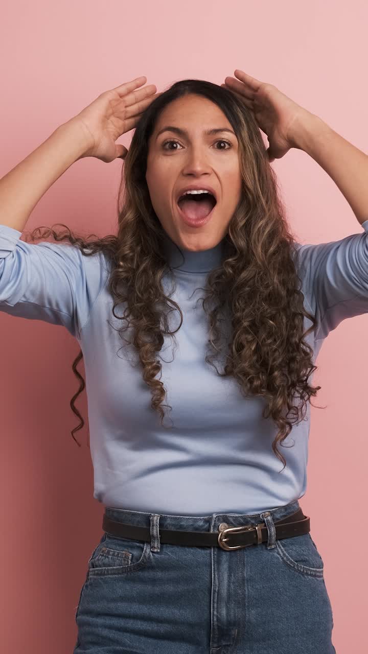 Surprised woman gesturing with mouth open looking at camera. Vertical footage