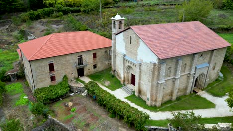 órbita aérea alrededor de la histórica iglesia española con techo de ladrillo rojo y hierba verde