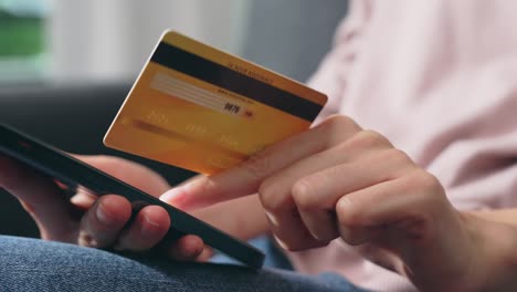 joven asiática con tarjeta de crédito y usando un teléfono inteligente para comprar en línea con pago en banca por internet.